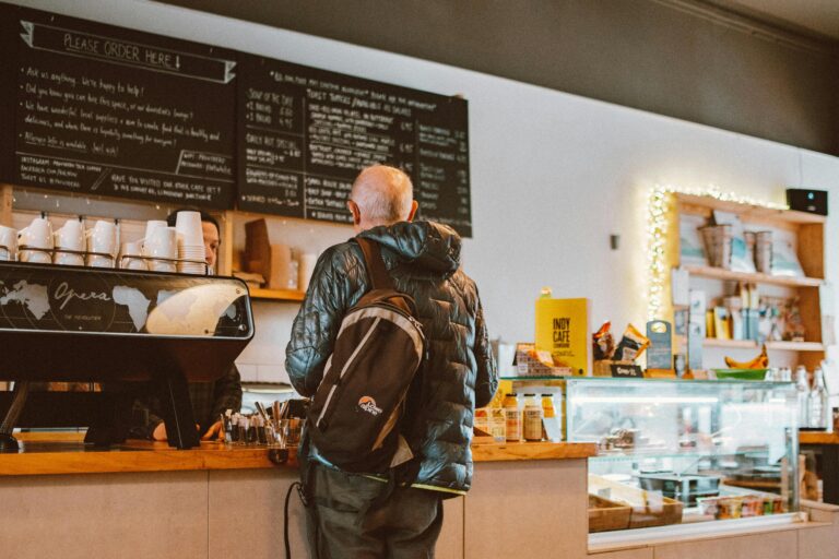 A casual café setting with a customer ordering coffee at the counter.