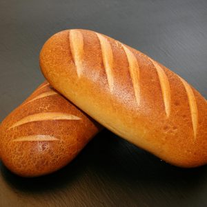 Close-up of two freshly baked loaves with crispy crust, ideal for food and still life photography.